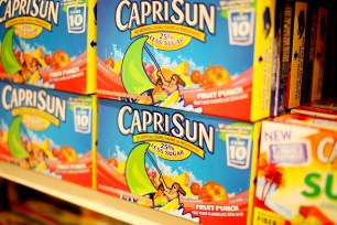 Boxes of Capri Sun juice on grocery store shelves, representing Walt Disney Company's plan to limit advertisements of unhealthy foods for kids