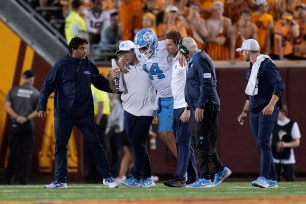 Max Johnson is helped off the field after an injury during the second half of an NCAA college football game against Minnesota on Aug. 29, 2024, in Minneapolis.